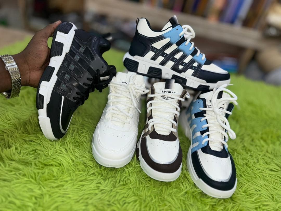 Person holding three pairs sneakers