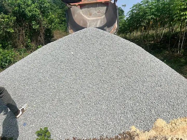Man standing next pile gravel